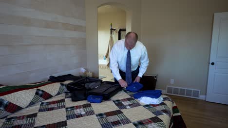 Older-executive-man-wearing-a-suit-packing-for-a-short-business-trip---time-lapse