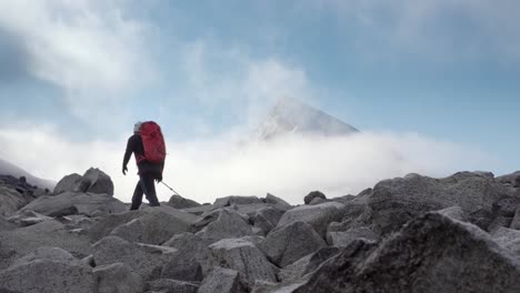 Foto-Espectacular-De-Una-Persona-Caminando-Con-El-Pico-De-La-Montaña-En-El-Fondo-Que-Surge-Por-Encima-De-Las-Nubes-Y-La-Niebla-Durante-El-Otoño