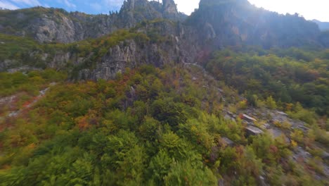 Vuelo-De-Drones-Por-Una-Montaña-Cubierta-De-Hermosos-árboles-De-Colores-Otoñales-En-Theth,-Albania