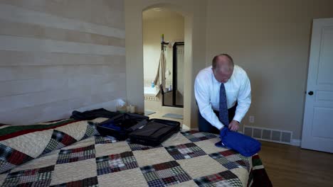 älterer-Leitender-Mann-In-Einem-Weißen-Hemd-Und-Einer-Krawatte,-Der-Packwürfel-Verwendet,-Um-Sein-Gepäck-Zu-Organisieren