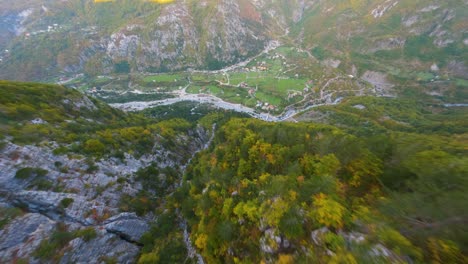 Drone-proximity-flight-down-a-mountain-towards-the-village-of-Theh-in-Albania-in-autumn