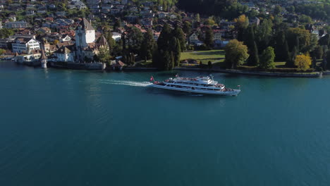fantastic-aerial-shot-of-tracking-over-a-passenger-ship-and-seeing-the-castle-of-Oberhofen-in-switzerland,-on-a-sunny-day