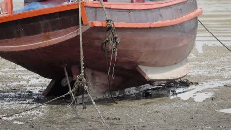 A-close-up-shot-of-the-stern-of-a-traditional-Thai-fishing-boat-moored-and-beached-during-low-tide-in-Thailand