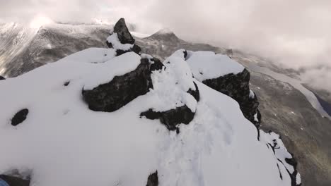 POV-shot-of-tapping-a-cairn-to-celebrate-summiting-a-demanding-mountain-in-mystical-weather
