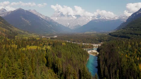 pan-right-and-dolly-forwards-zoom-shot-of-the-fraser-river-in-Mount-Robson-Provincial-Park-in-British-Columbia-in-Canada-on-a-sun-and-clouds-day-surrounded-by-forest-and-snow-on-the-mountain-peaks