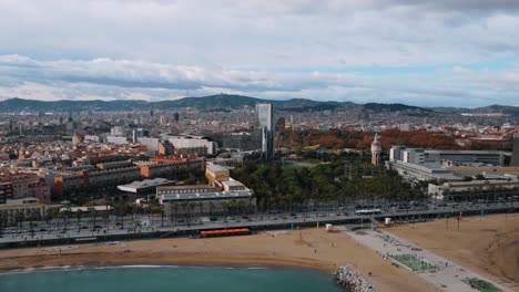 Barceloneta-Drone-Epische-Strandansicht-Stadt-Im-Hintergrund-Mit-Bunter-Natur-Und-Urbanismus-Moderne-Kunst-4k-Filmmaterial-Barcelona,-Spanien