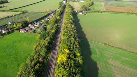 Dolly-forward-towards-a-countryside-train-station-with-beautiful-coloured-trees
