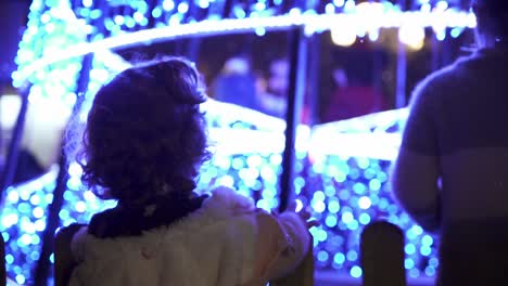 Slow-motion-medium-panning-shot-of-a-child-admiring-the-christmas-lights-in-medina-sidonia-and-looking-upwards