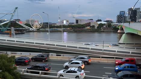 Timelapse-dusk-shot-capturing-Brisbane-city-pacific-motorway-traffics-at-rush-hour-after-work,-overlooking-at-south-Brisbane-parklands-across-the-river,-Queensland,-Australia