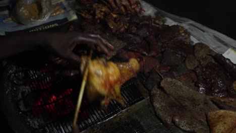 African-Street-food-butcher-grills-meat-on-charcoal-grill-for-sale-at-night