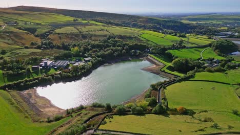 Aerial-drone-video-footage-taken-at-Ogden-Saddleworth-moor-in-Oldham,-England-of-a-series-of-Lakes,-Reservoirs,-set-against-a-backdrop-of-moorland,-woodlands-and-farmland-pastures