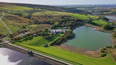 Rural-aerial-drone-video-footage-taken-at-Ogden-Saddleworth-moor-in-Oldham,-England-of-a-series-of-Lakes,-Reservoirs,-set-against-a-backdrop-of-moorland,-woodlands-and-farmland-pastures
