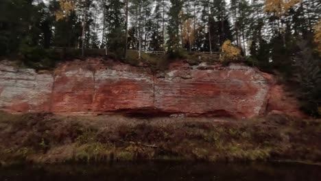 The-Echo-Cliff,-Red-Sandstone-Skanaiskalns-Cliffs-at-the-River-Salaca-in-Skanaiskalns-Nature-Park-Mazsalaca,-Latvia,-Autumn-Time