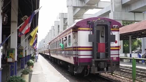 Conductor-putting-a-green-flag-out-of-the-train-in-Bangkok