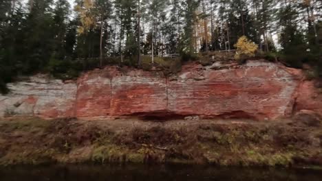 The-Echo-Cliff,-Red-Sandstone-Skanaiskalns-Cliffs-at-the-River-Salaca-in-Skanaiskalns-Nature-Park-Mazsalaca,-Latvia,-Autumn-Time