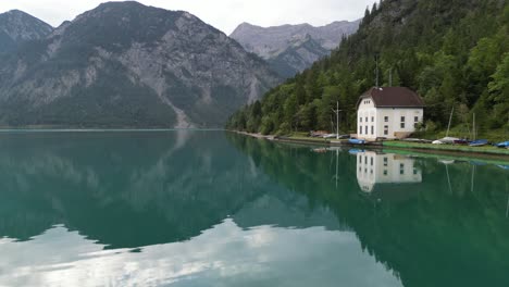 Early-morning-over-Lake-in-Tyrol-Austria-clear-still-water-drone-aerial-view-4K