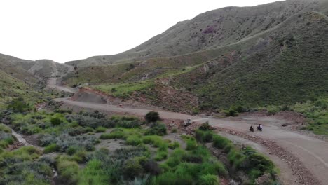 Aerial-View-Of-Motorbikes-Driving-Along-Remote-Road-Through-Mountainous-Valleys-In-Khuzdar