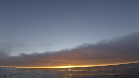 Zeitlupe-Eines-Fantasy-Sonnenuntergangs-über-Einem-Nahtlos-Geschlungenen-Ozean-Mit-Einigen-Wolken