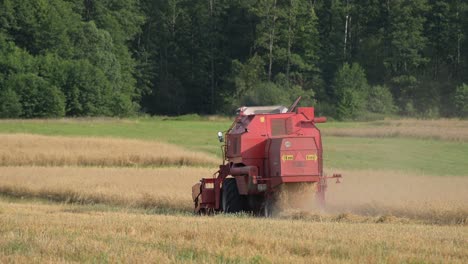 Weizenerntesaison-Rote-Traktorerntemaschine,-Die-Auf-Einem-Ackerland-Auf-Dem-Land-Arbeitet,-Nahrungskettenkonzept