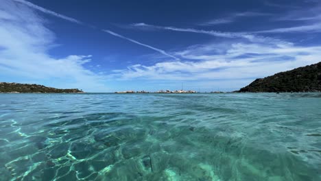 Low-angle-sea-water-surface-point-of-view-of-Santa-Giulia-emerald-colored-water-in-Corsica-island,-France