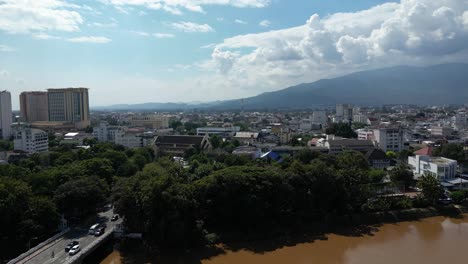 Slow-rising-aerial-shot-over-Ping-River-with-Chiang-Mai-City-in-distance