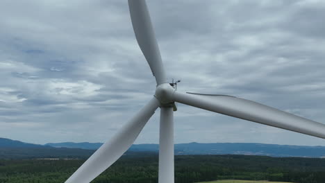Windturbine-Aus-Nächster-Nähe,-Sich-Drehende-Rotorblätter-Unter-Bewölktem-Himmel,-Grünes-Energiekonzept,-Statischer-Drohnenschuss