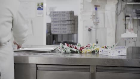 Slow-motion-handheld-panning-shot-of-an-employee-in-a-candy-factory-in-medina-sidonia-putting-packaged-candy-aside