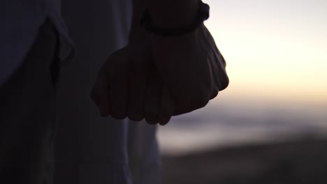 Slow-motion-handheld-shot-of-a-couple-in-love-holding-hands-on-the-beach-during-a-romantic-sunset-by-the-sea
