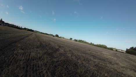 Fpv-Drohne-über-Landwirtschaftlichem-Ackerland,-Das-über-Landschaftsbaumhecke-Uk-Geht