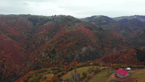 Luftaufnahme-Eines-Hauses-In-Einem-Bergtal-Mit-Herbstfarbenwald