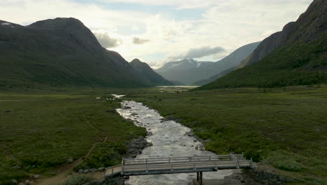 Meandering-River-Through-Green-Fields-In-Mountainous-Landscape-Of-Jotunheimen-In-Norway