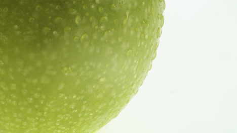 Close-up-shot-of-an-green-apple-with-water-drops-on-it