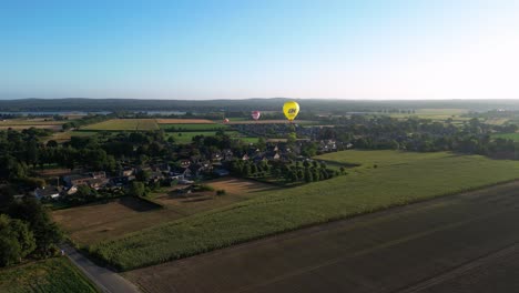 Luftaufnahmen-Von-Heißluftballons,-Die-Während-Des-Morgendlichen-Sonnenaufgangs-über-Die-Ländliche-Landschaft-In-Den-Niederlanden-Fliegen
