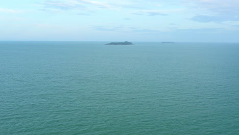 Luftdrohne-Einer-Abgelegenen-Tropischen-Insel-Am-Horizont-Des-Blauen-Ozeans-Vor-Der-Küste-Von-Nord-Queensland,-4k