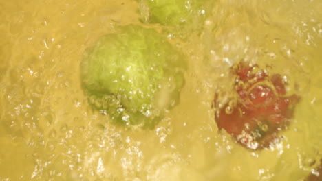 Close-up-shot-of-apples-with-different-color-dropping-in-water