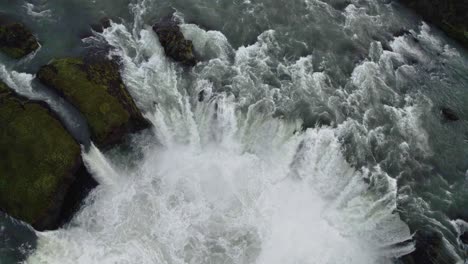 Drone-Volando-Hacia-Atrás-Con-La-Cámara-Inclinándose-Hacia-Arriba-Filmando-Una-Gran-Cascada-Formada-Por-Cirulair-En-Islandia-En-4k