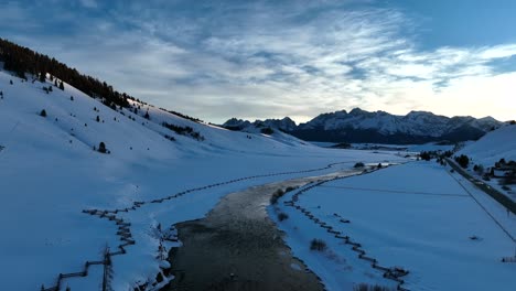 Frozen-Landscape-And-Flowing-River-With-Wooden-Fence-In-Sawtooth-Mountains,-Sun-Valley,-Central-Idaho