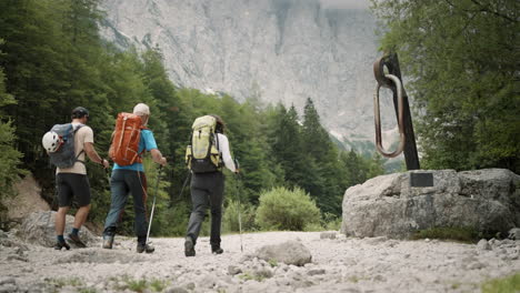 Hikers-walking-past-the-camera-forward-towards-the-mountain-past-the-Climbing-Carabiner-statue