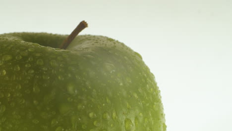 Close-up-shot-of-an-green-apple-with-water-drops-on-it