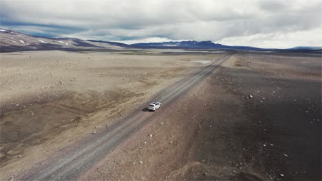Dron-Siguiendo-Un-Automóvil-Plateado-Que-Conduce-Fuera-De-La-Carretera-En-El-Campo-Lunar-De-Islandia-En-4k