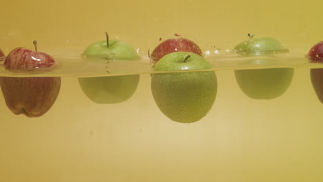 Schuss-Von-Einem-Haufen-Äpfel-Mit-Verschiedenen-Farben,-Die-Auf-Dem-Wasser-Schwimmen
