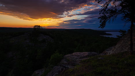 Time-lapse-of-a-bright-gold-sunset-over-the-forests-of-Michigan's-Upper-Peninsula,-shot-on-the-Lake-Superior-shore-line-in-4K