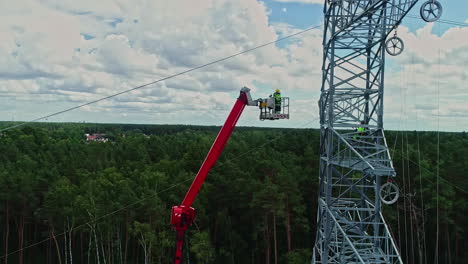 High-voltage-electrician-on-a-crane-with-mobile-elevating-work-platform-to-inspect-a-pylon