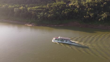 Tourboat-on-tourist-boat-along-placid-waters-of-Iguazu-river,-border-between-Argentina-and-Brazil