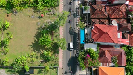 Luftaufnahme-Von-Oben-Nach-Unten-Aus-Autos-Und-Motorrädern-Herauszoomen,-Die-Auf-Der-Straße-In-Lovina-Bali-Indonesien-Fahren
