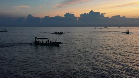 Antena-De-Muchos-Barcos-Jukung-Con-Turistas-En-Un-Vasto-Océano-Plano-Durante-La-Gira-Del-Amanecer-En-Lovina-Bali-Indonesia