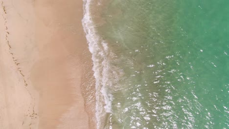 Above-aerial-shot-facing-down-on-luxurious-beach-with-turquoise-waters
