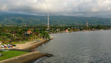 beautiful-coastline-landscape-of-large-mountains-and-tropical-water-in-Lovina-Bali-Indonesia-at-sunset,-aerial