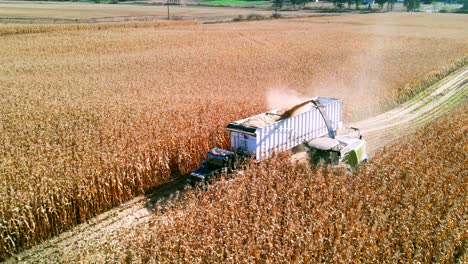 backwards-flight-over-farm-vehicles-gathering-corn-during-harvest-season