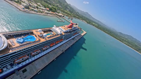 Crazy-racing-drone-flying-over-anchored-cruise-ship-and-over-ocean-villas-resort,-Puerto-Plata-in-Dominican-Republic